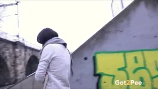 Frau pisst im Winter in einer Stadt