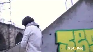 Frau pisst im Winter in einer Stadt